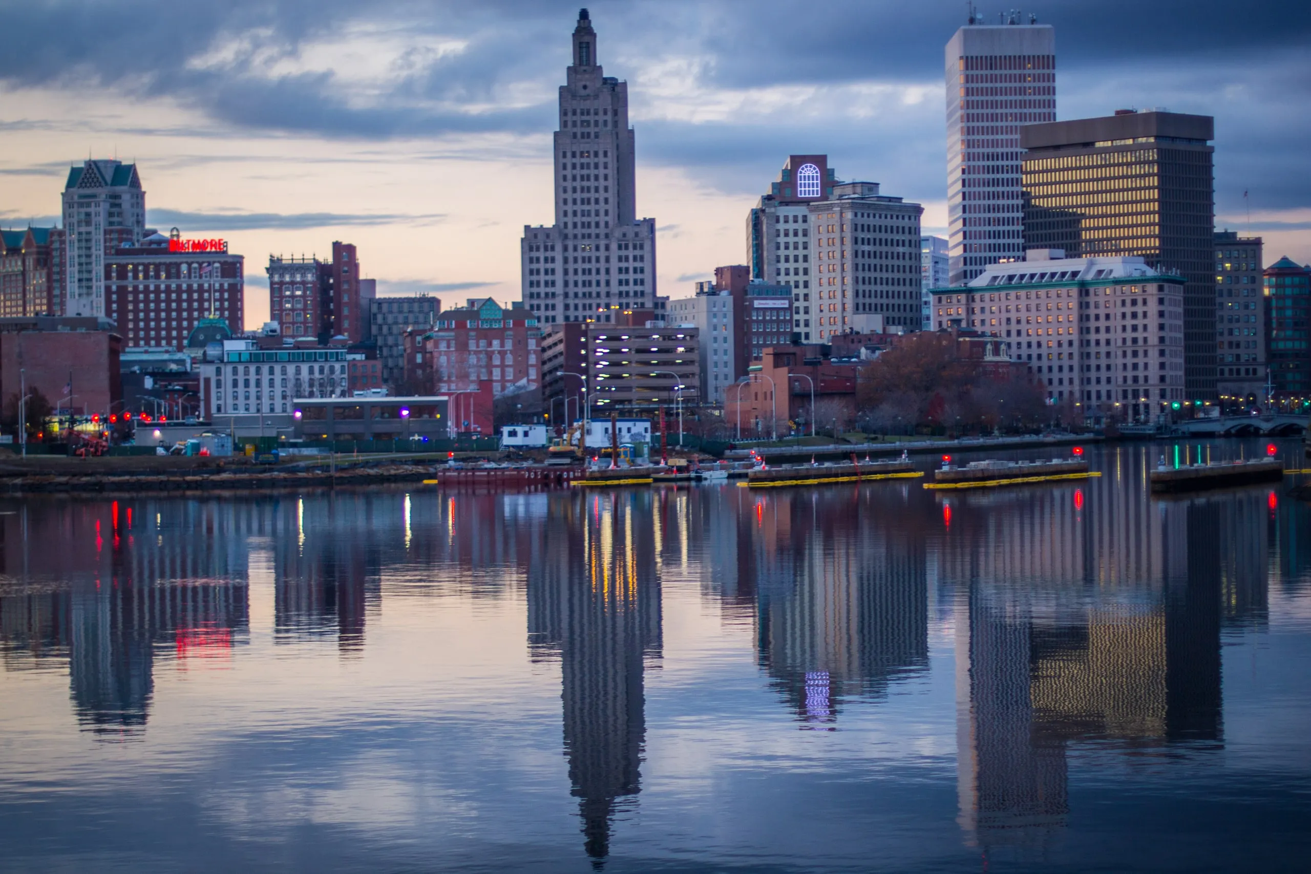 City skyline reflected in a calm river at dusk