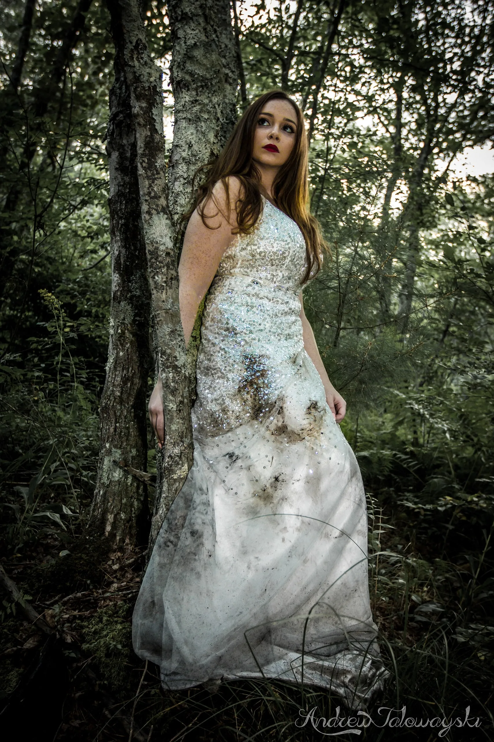Woman in a white gown standing in a forest