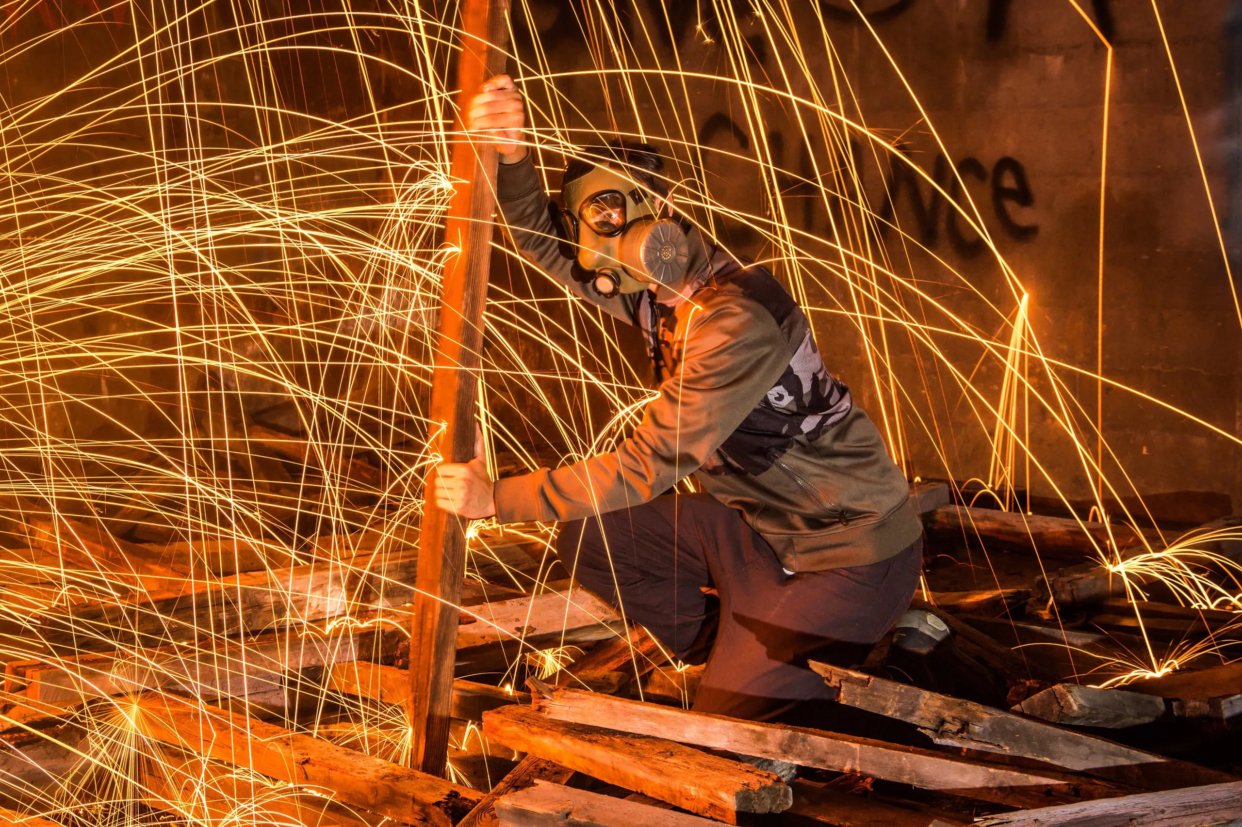 Steel-wool sparks spinning around a person in a workshop