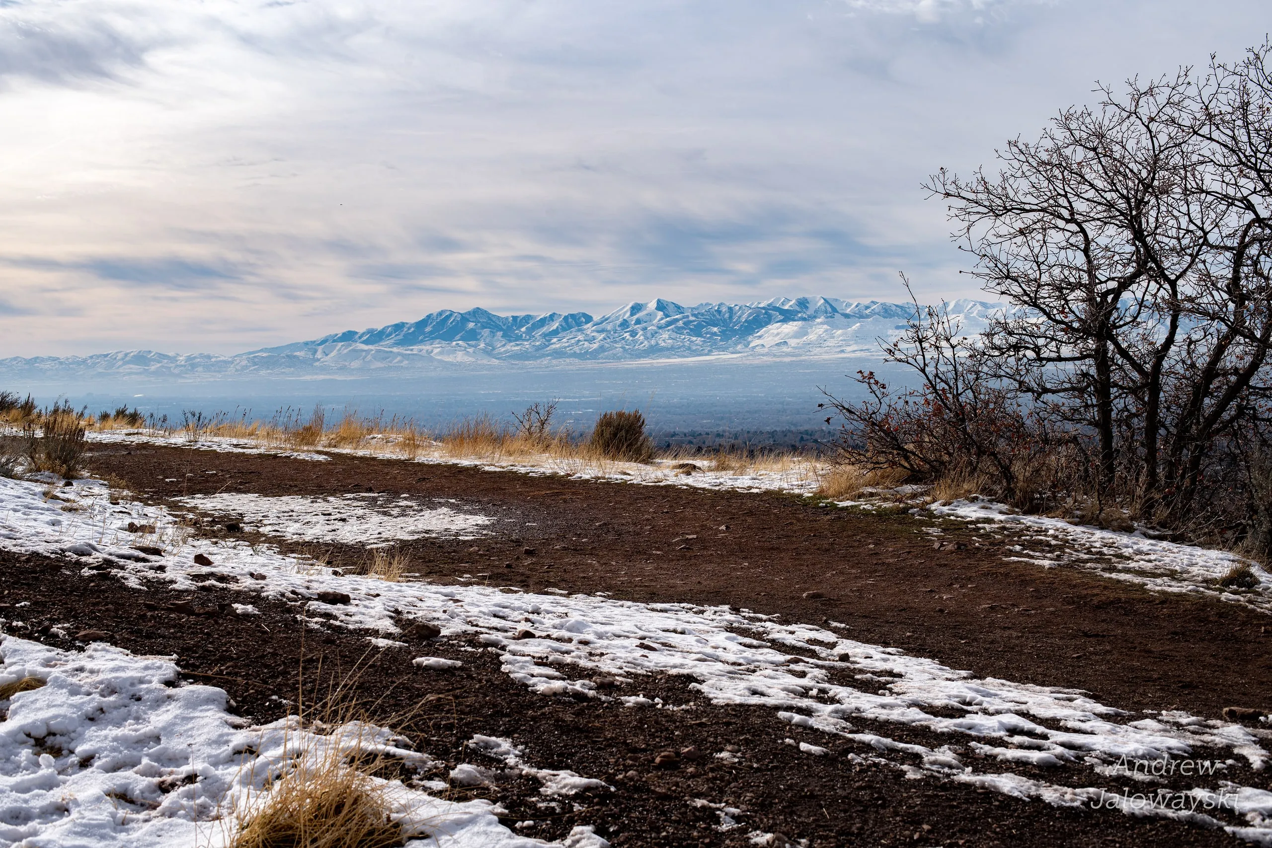 Patchy snow on a hilltop overlooking the Salt Lake valley and distant mountains