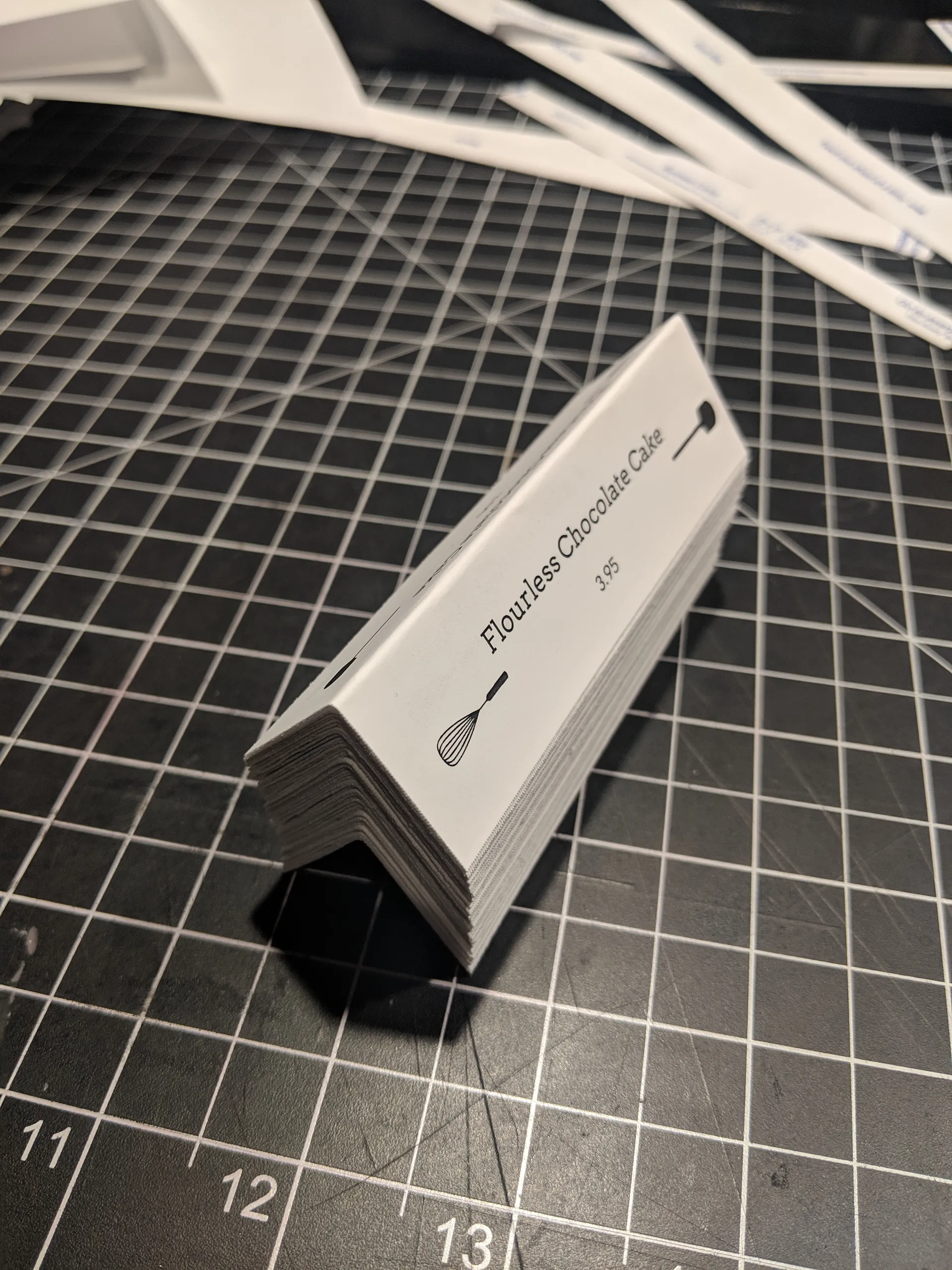 Folded Whisk & Paddle table tent on a cutting mat