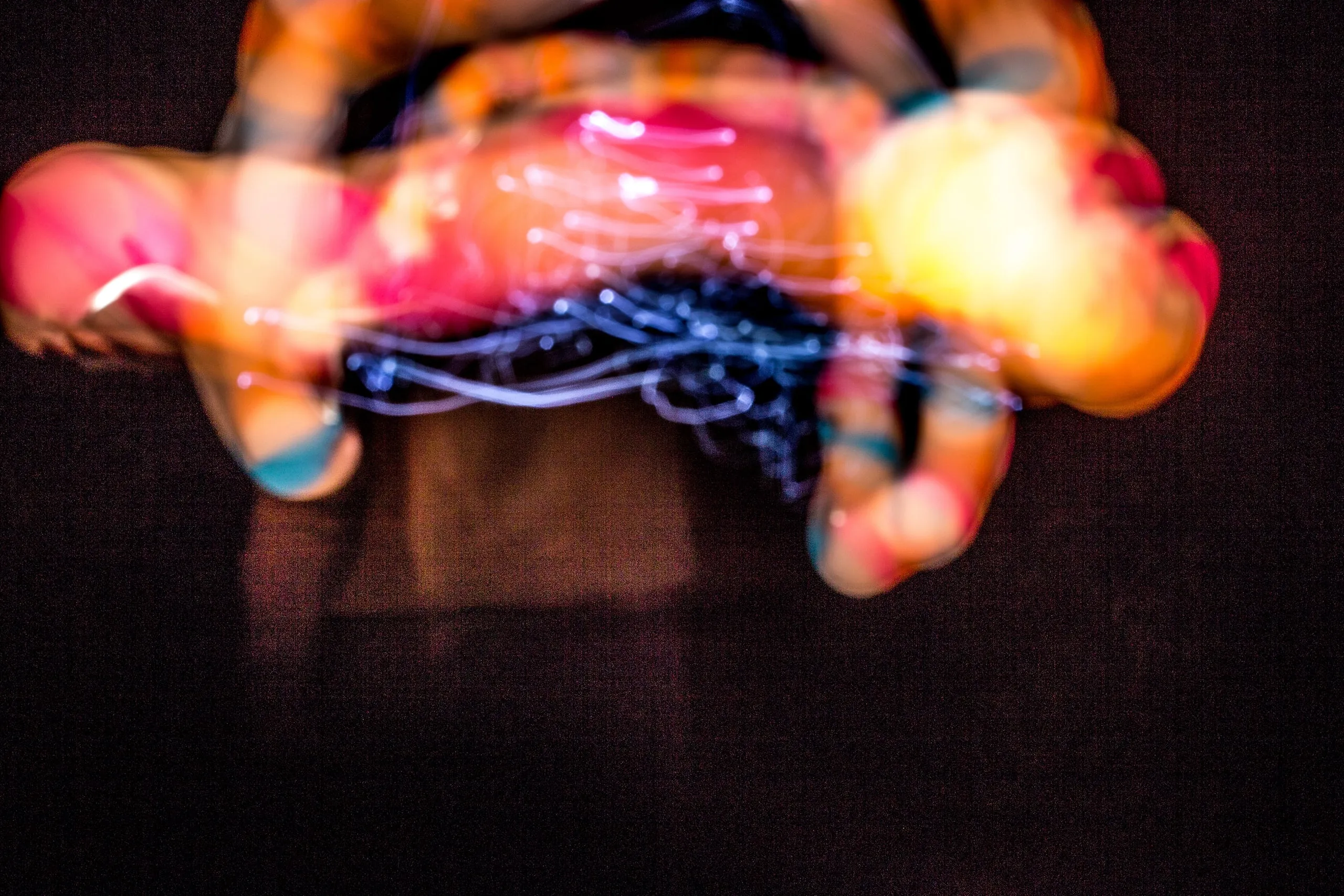 Blurred hands holding an orb surrounded by swirling light trails
