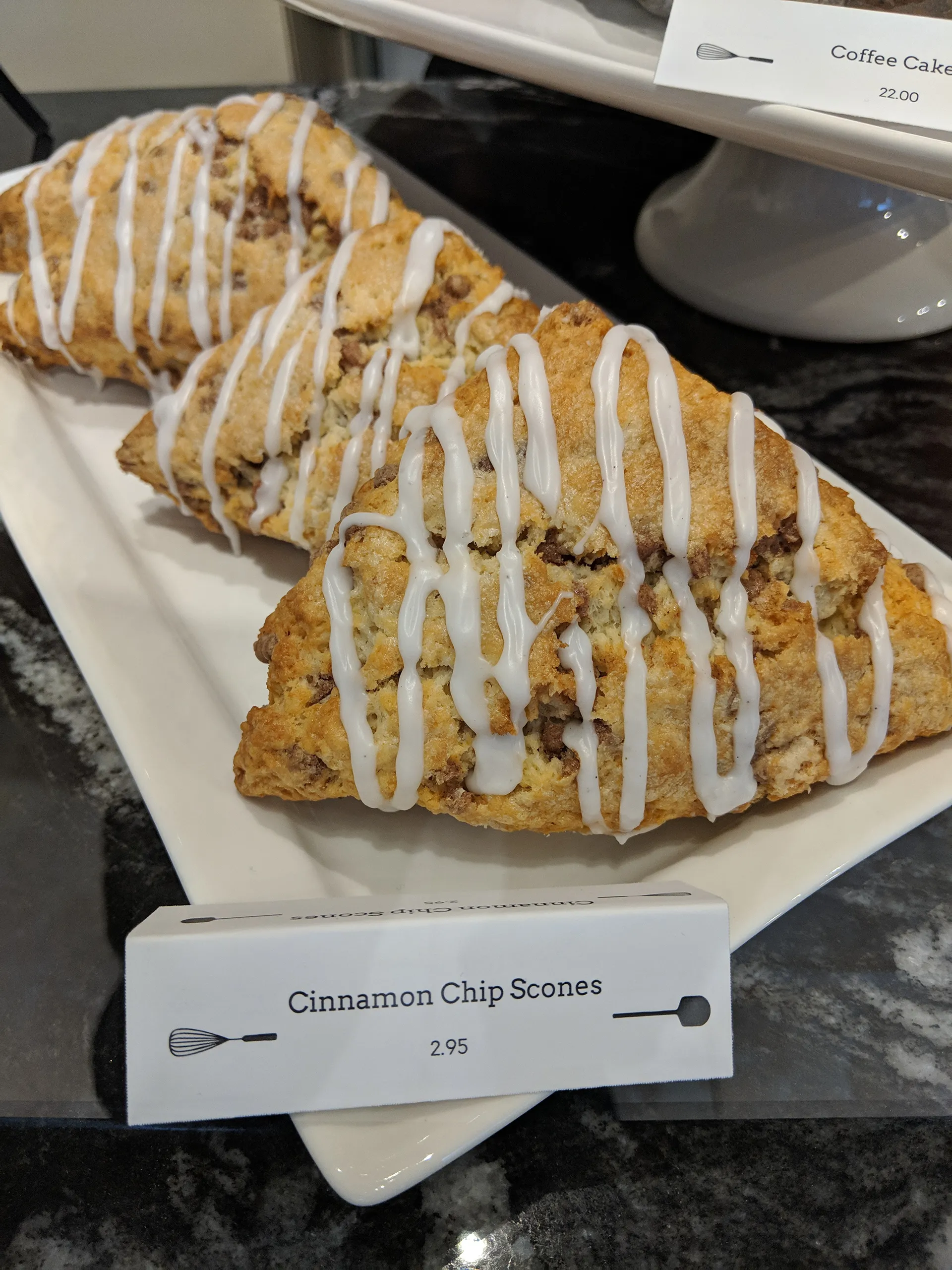 Cinnamon chip scones on a platter with a printed Whisk & Paddle label