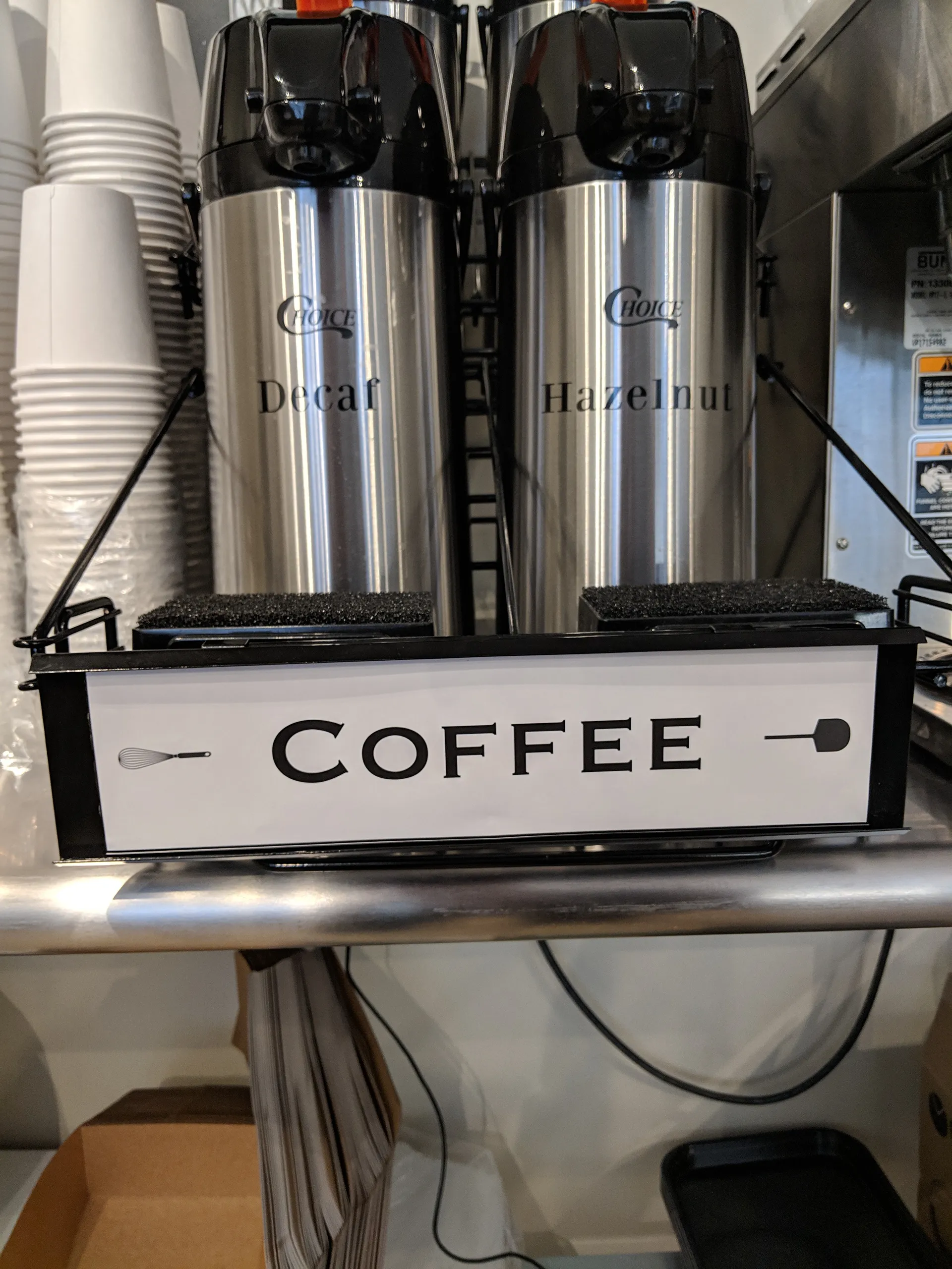 Coffee dispensers under a Whisk & Paddle COFFEE sign