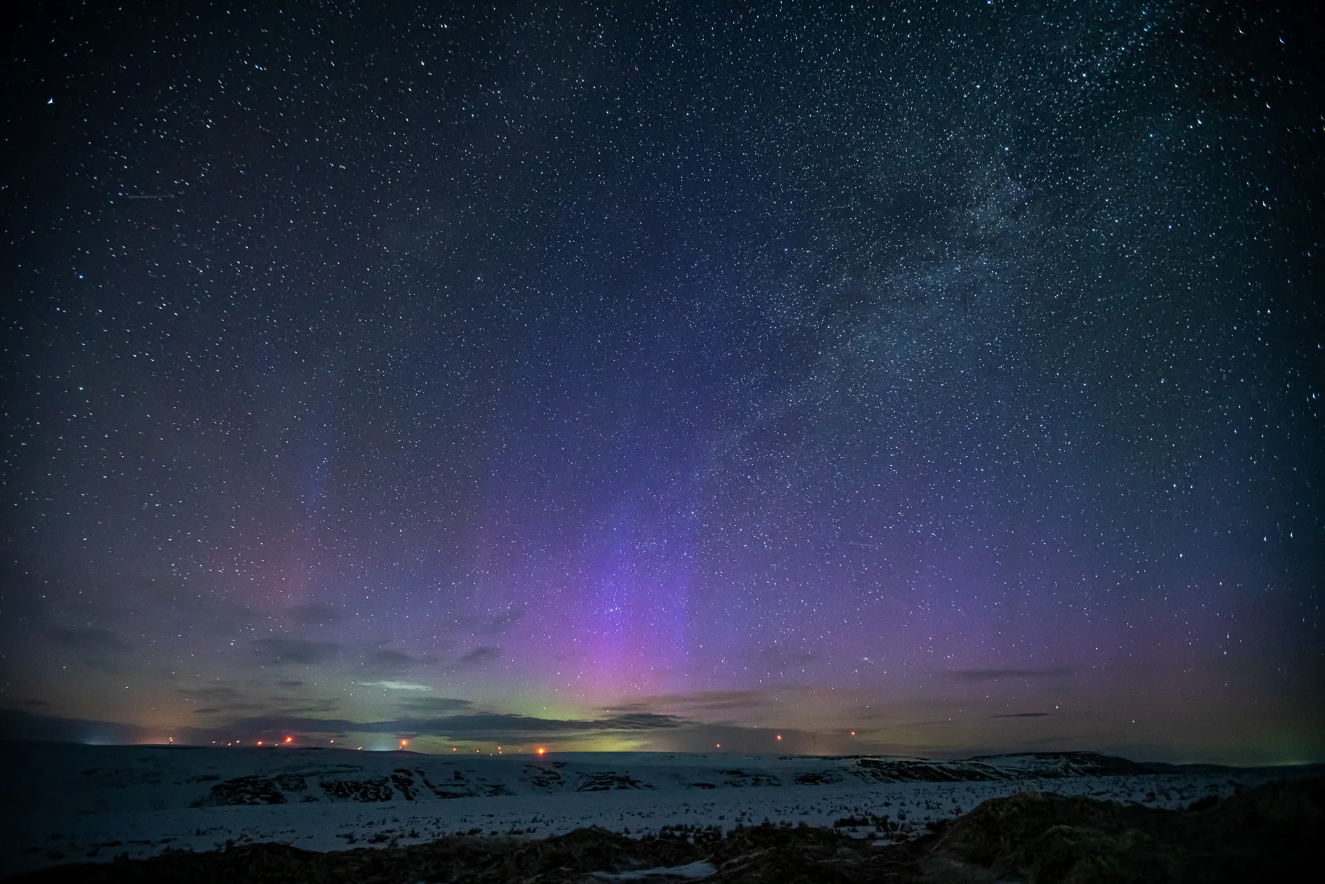 Faint purple aurora glowing on the horizon under a starry sky