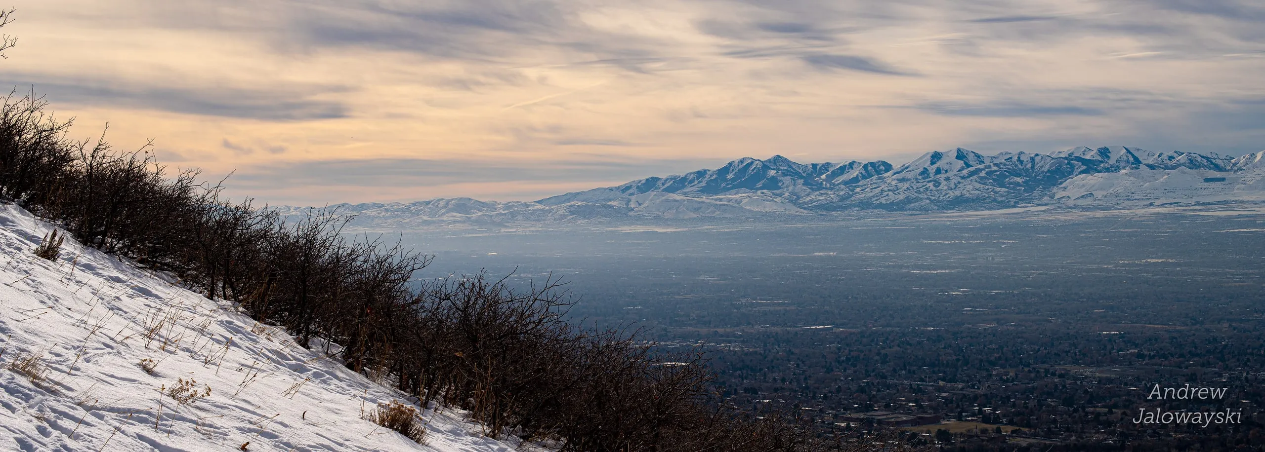 Hazy Salt Lake valley seen from a snowy ridge