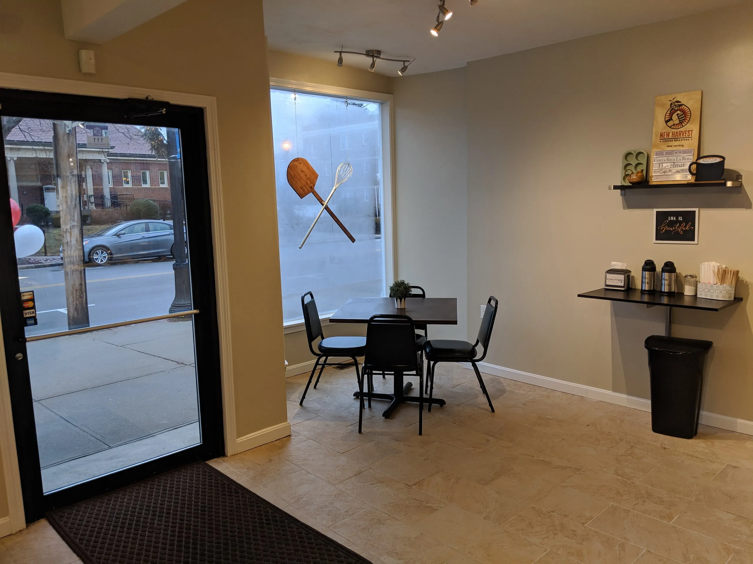Bright bakery café interior with a small table and the window logo