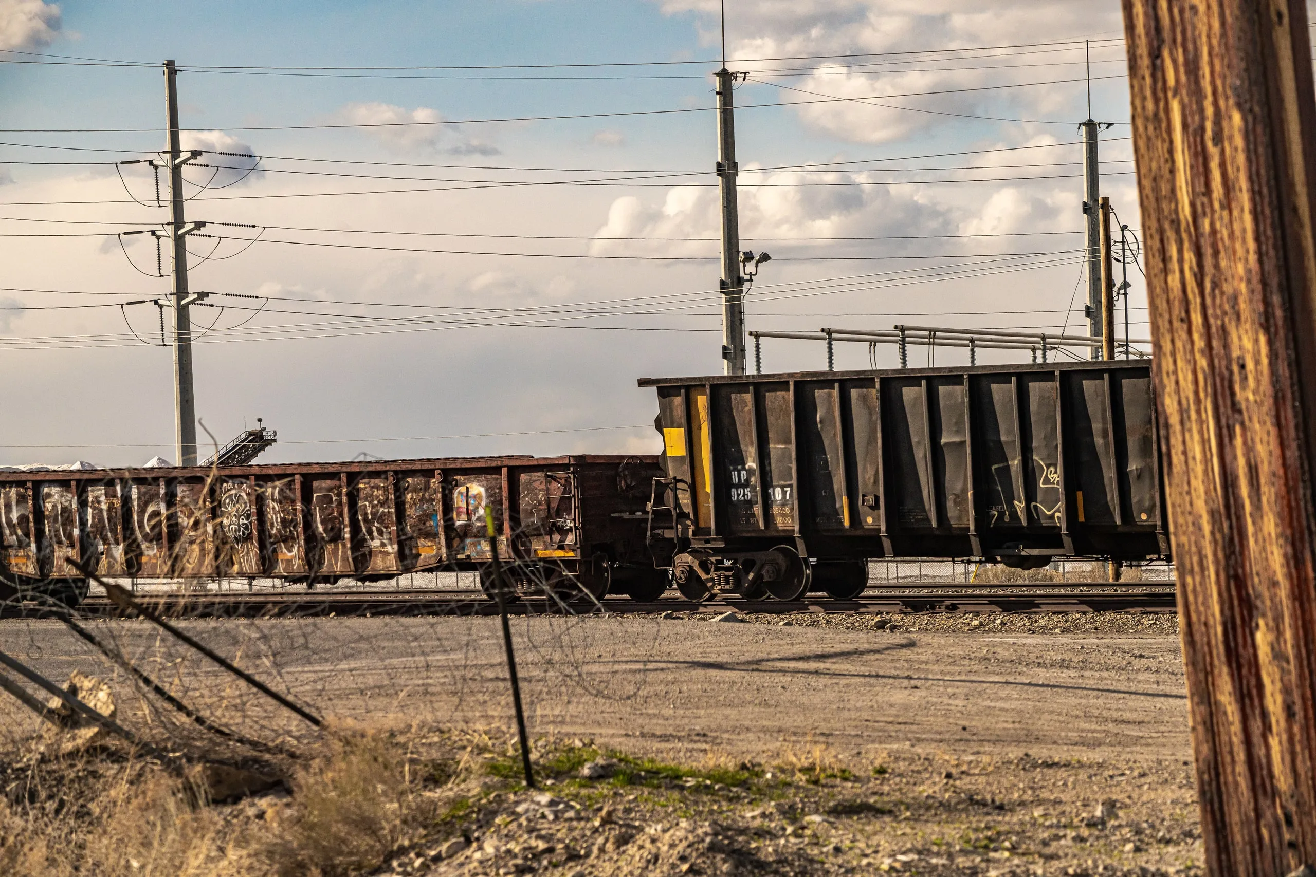 Railway freight cars and power lines in a rural rail yard