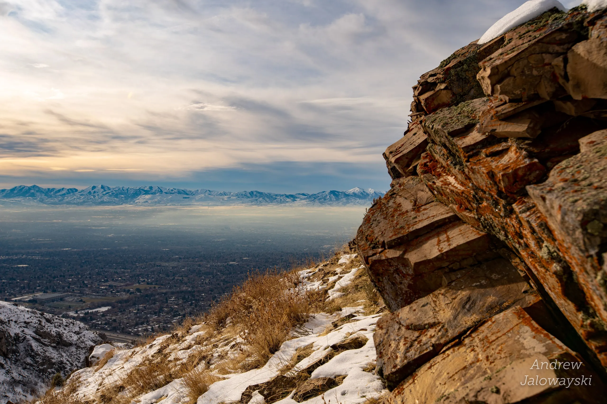 Red rock outcrop on a snowy slope overlooking the valley