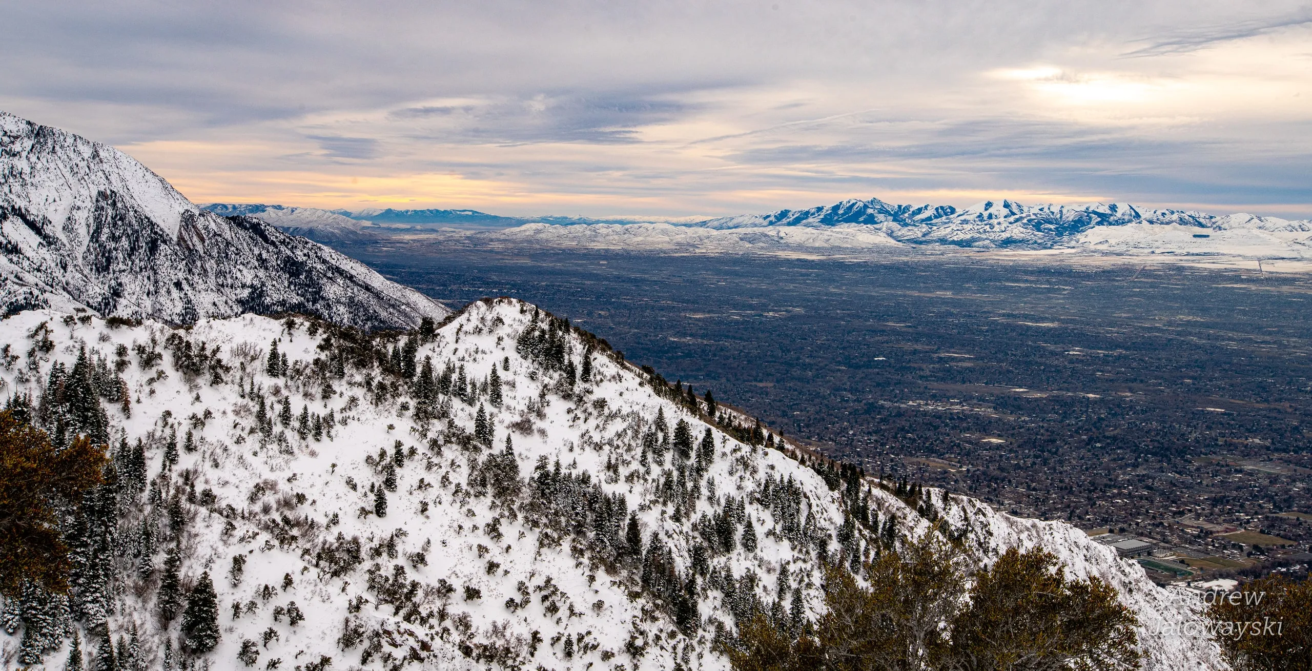 Snowy ridge overlooking the Salt Lake valley under a cloudy sky