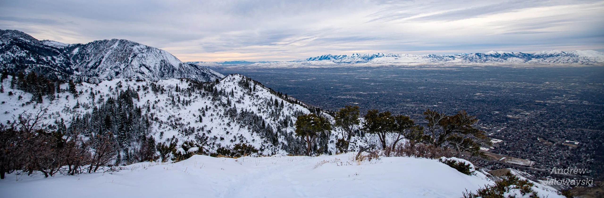 Wide view of snowy ridges and the valley at dusk