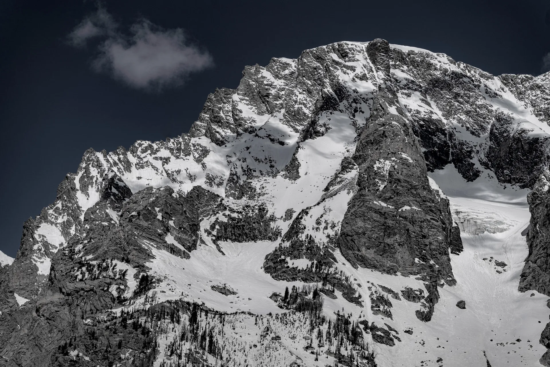 Black-and-white close-up of a rugged snow-streaked Teton peak