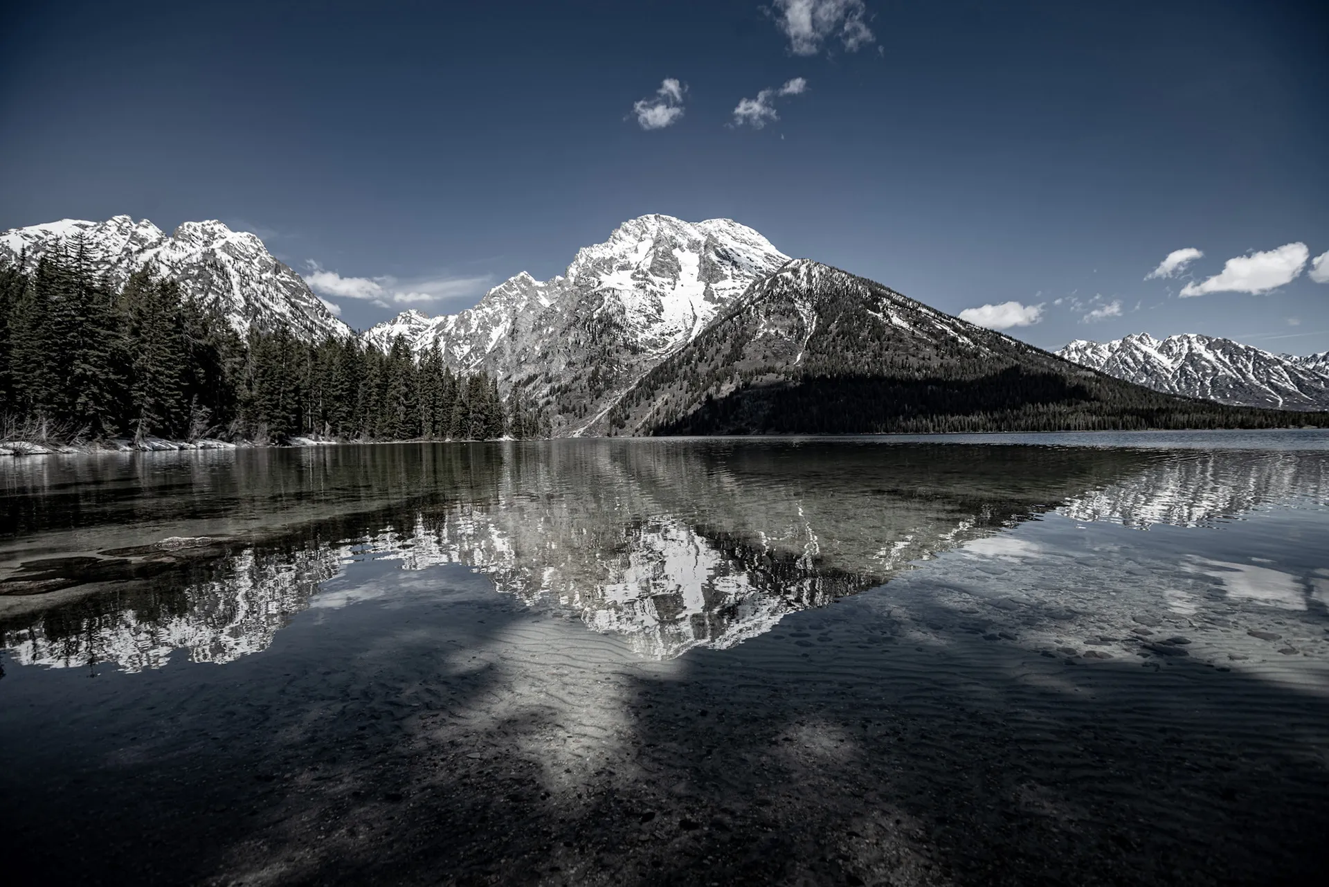 Teton range and pine forest mirrored in a calm lake