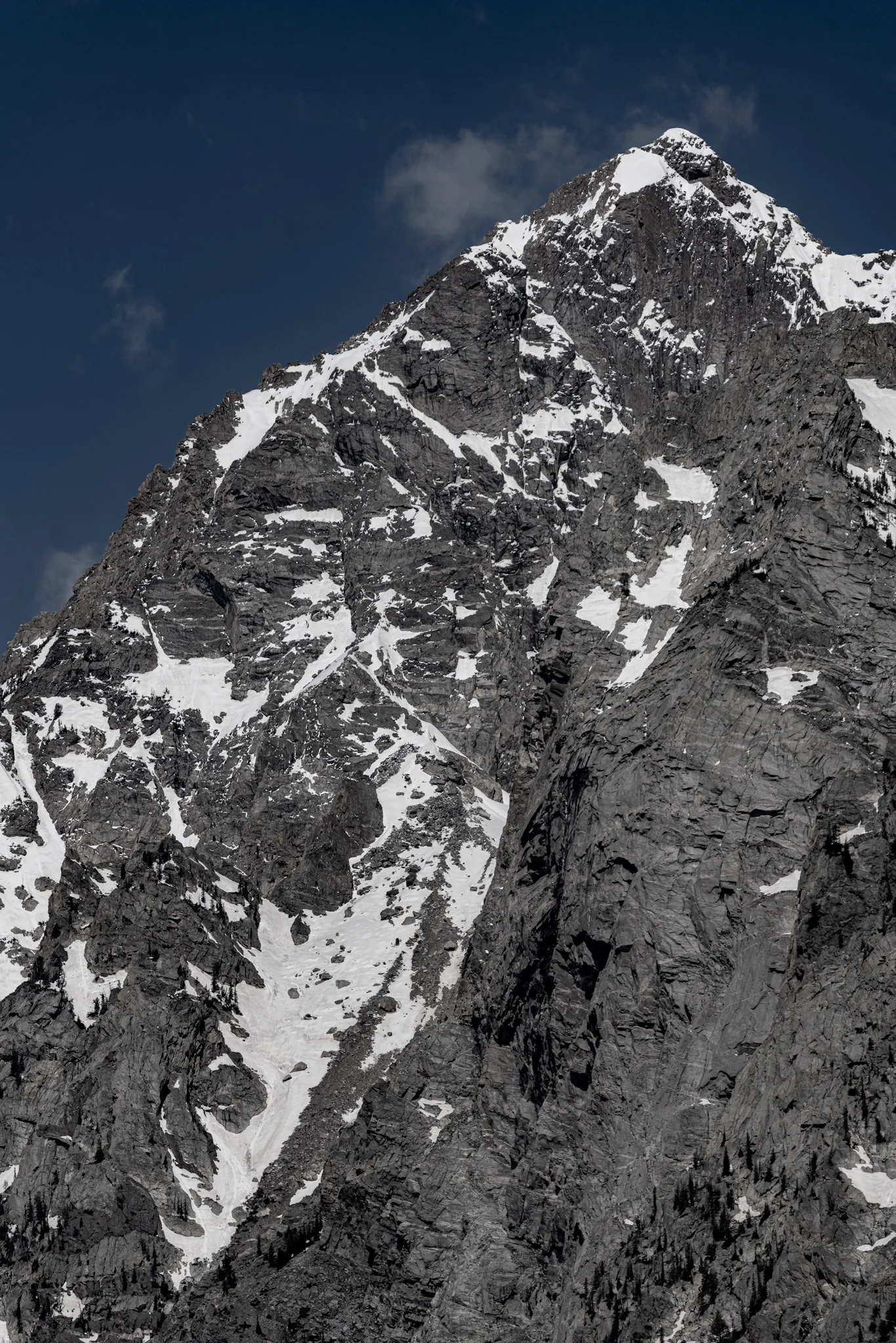 Black-and-white vertical view of a snowy Teton summit