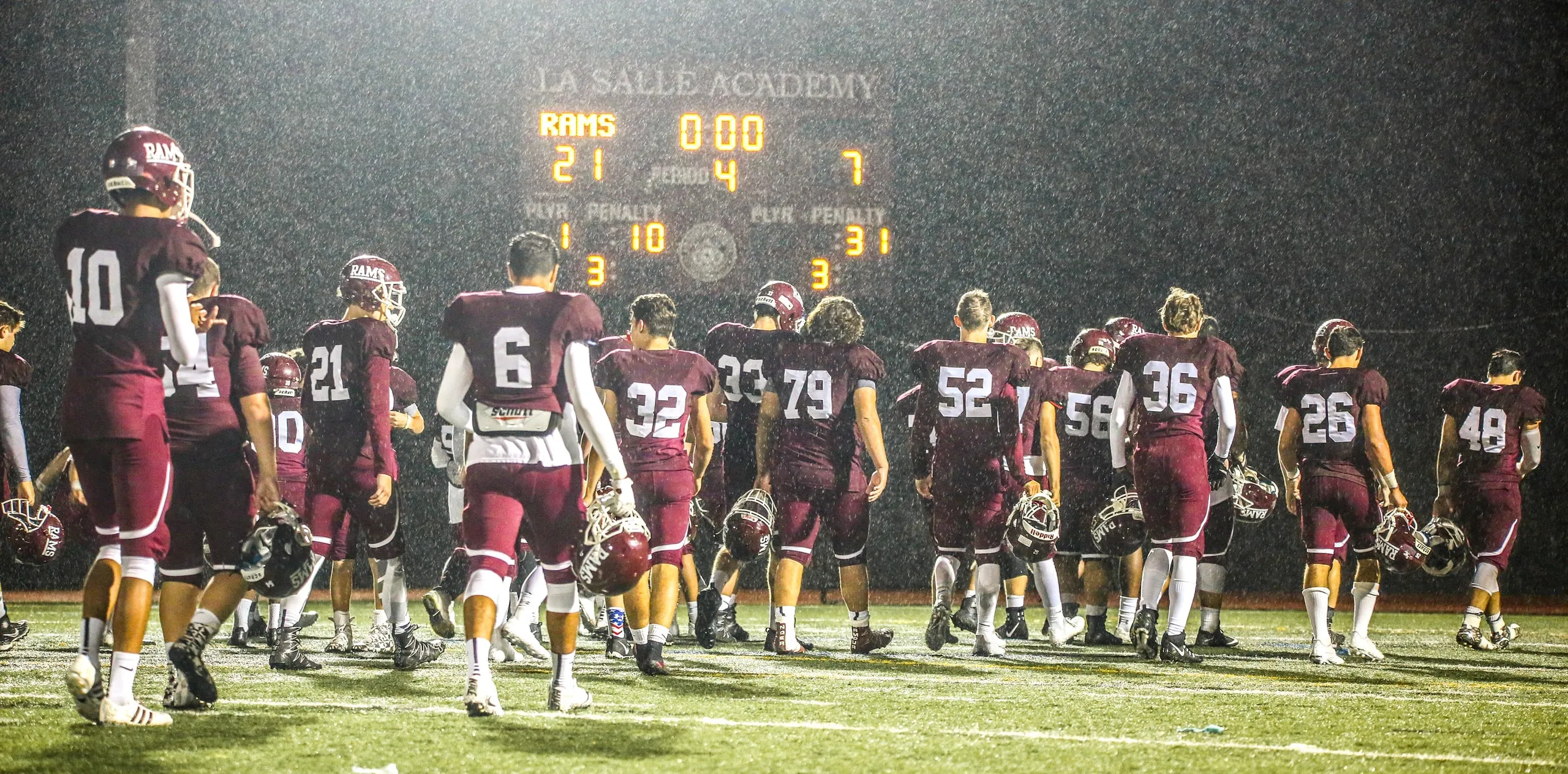 Football team on the field at night in front of the scoreboard