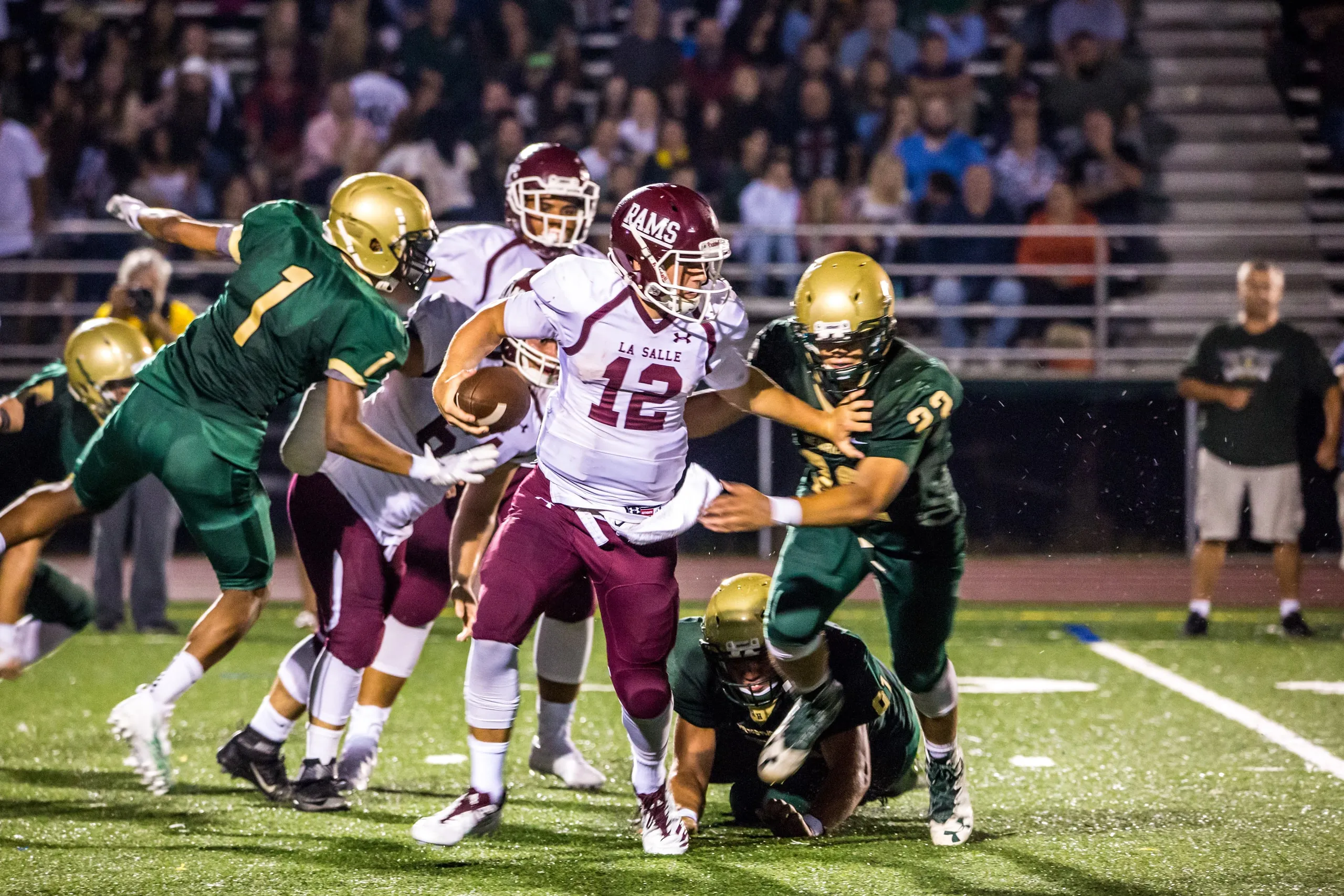 High school football players colliding during a night game