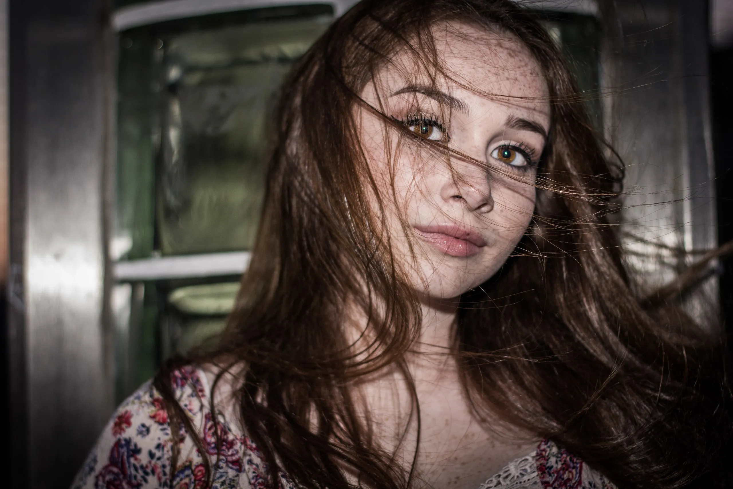 Portrait of a young woman with long brown hair looking at the camera