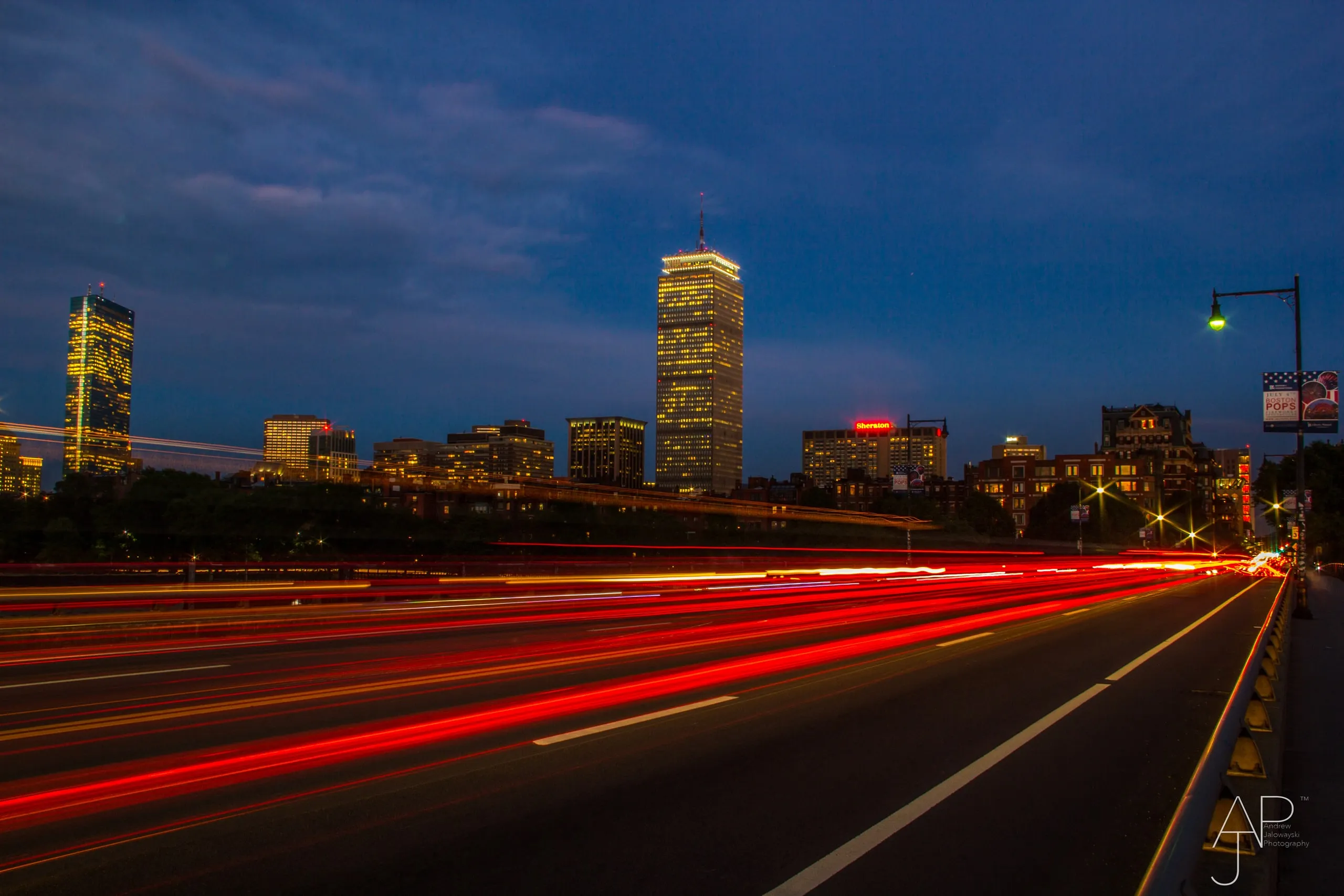Light trails from traffic on a highway with a city skyline at dusk